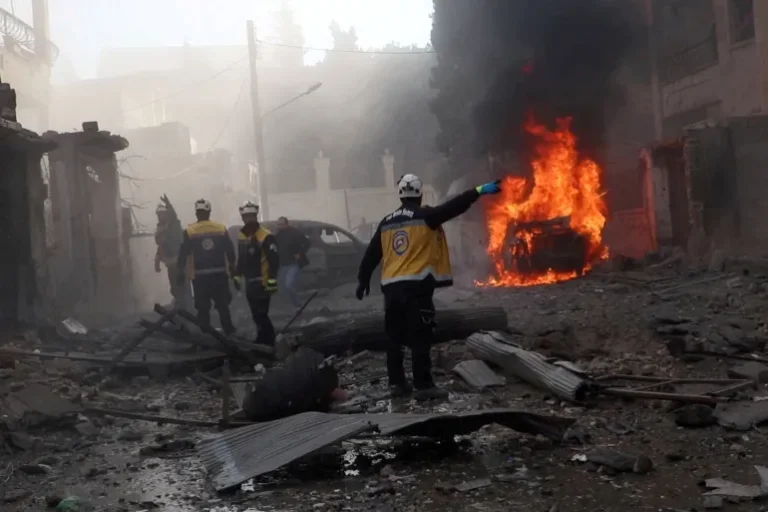 عاملون في منظمة الخوذ البيضاء يبحثون عن ناجين بعد غارات جوية استهدفت مدينة إدلب (رويترز)