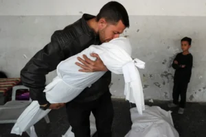 فلسطيني يحمل طفلة استشهدت في غارة إسرائيلية على مدينة غزة (رويترز)
