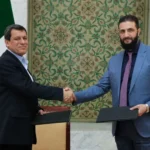 أحمد الشرع (يمين) يصافح مظلوم عبدي بعد توقيع اتفاق مارس/آذار (الفرنسية)