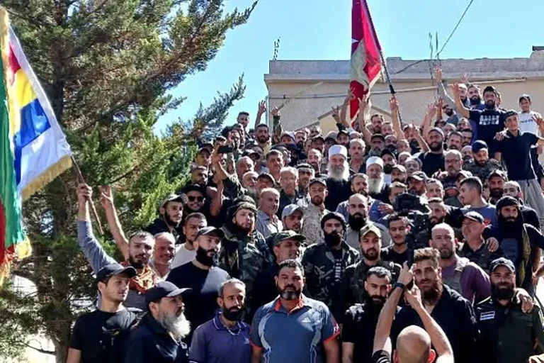 الهجري يتوسط مسلحين دروزا أثناء انضمامهم إلى الحرس الوطني (الجزيرة)