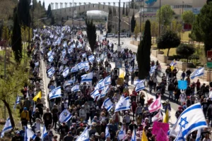 متظاهرون يحملون الأعلام الإسرائيلية خلال مسيرة ضد الحكومة الإسرائيلية في 23 مارس 2025 في القدس (غيتي)