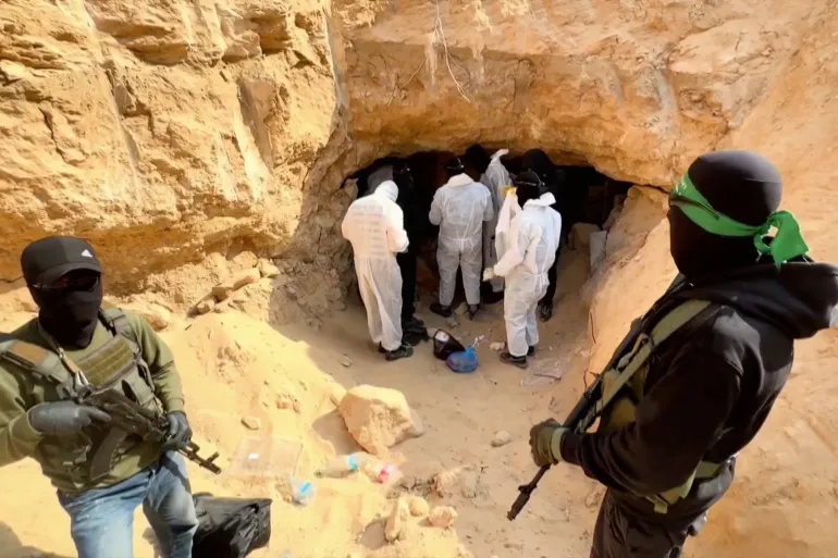 عناصر من كتائب القسام بصحبة فريق من الصليب الأحمر في أثناء انتشال جثة غولدن من نفق غربي مدينة رفح (الجزيرة)