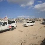 عناصر من الصليب الأحمر مع مقاتلين من كتائب القسام خلال التوجه نحو حي الزيتون للبحث عن جثث الأسرى (رويترز)