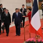 ماكرون (يسار) وشي جين بينغ خلال مراسم الاستقبال الرسمية في قاعة الشعب الكبرى ببكين (غيتي)